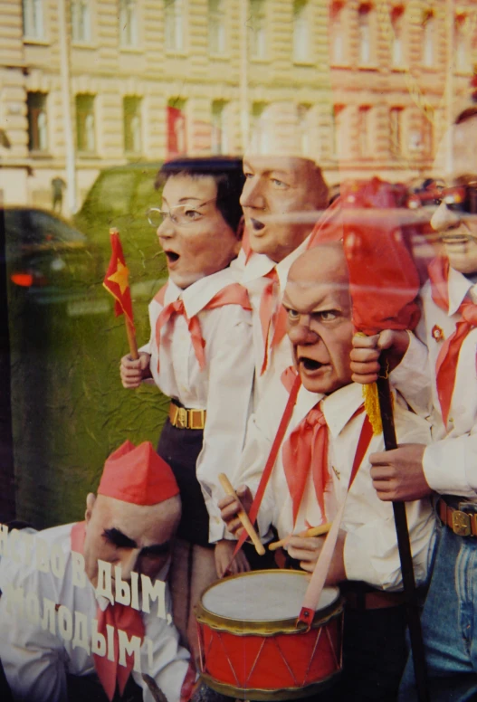 a group of men standing next to each other in front of a building, an album cover, inspired by Lajos Gulácsy, flickr, socialist realism, red horns, parade, 1999 photograph, close - up of the faces