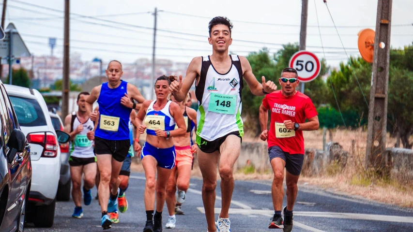 a group of people running down a street, by Luis Miranda, pexels contest winner, sprinters in a race, profile image, male, panels