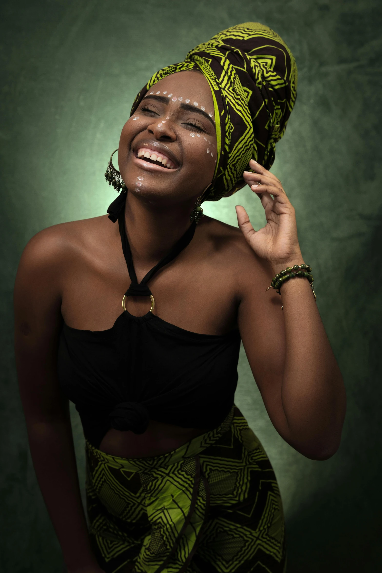 a woman in a black top and green skirt, shutterstock contest winner, afrofuturism, dramatic smile pose, cloth head wrap, akt photography, smiling young woman