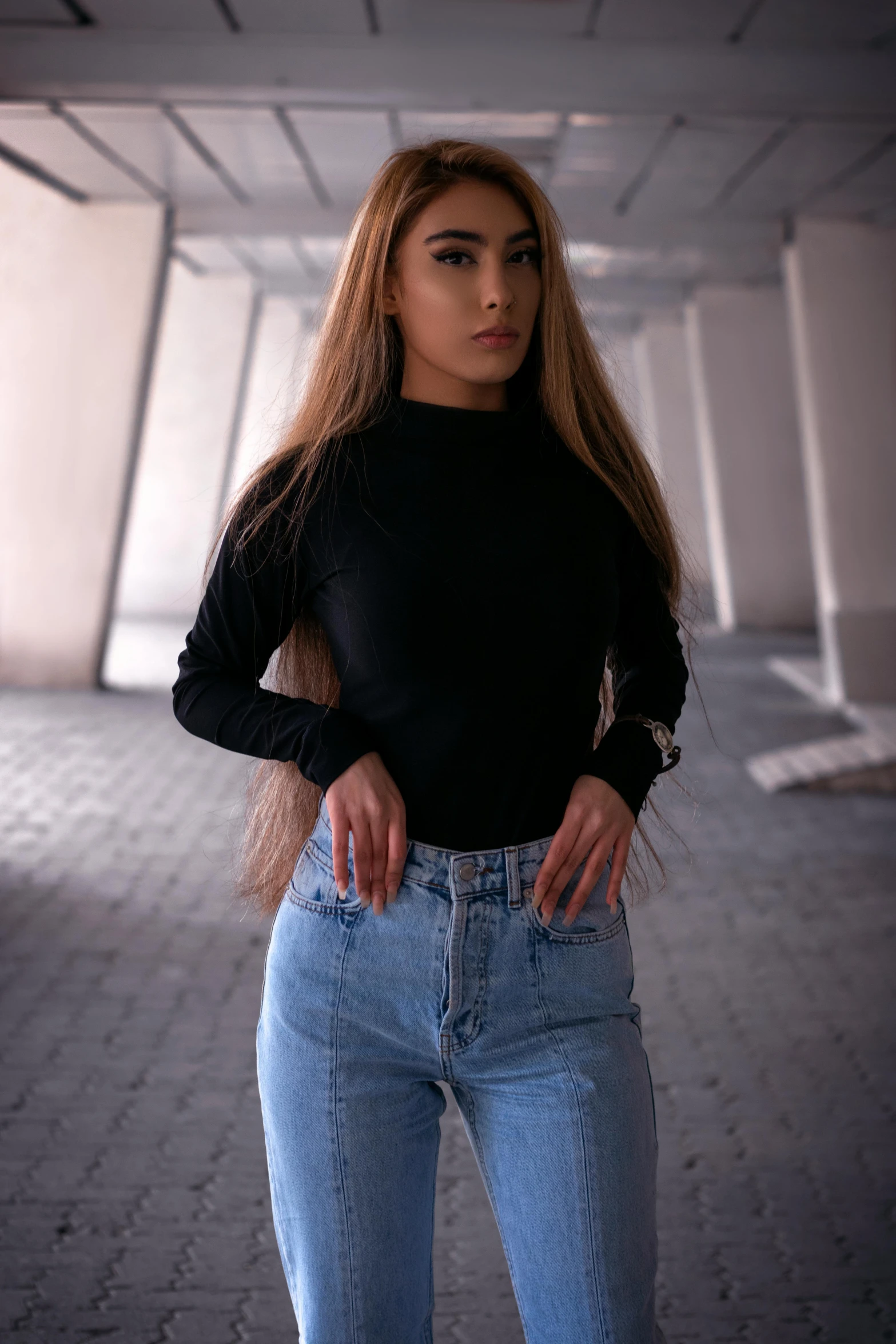 a woman in a black top and jeans posing for a picture, inspired by Elsa Bleda, trending on pexels, renaissance, long sleeve, light skin, round-cropped, long hair girl