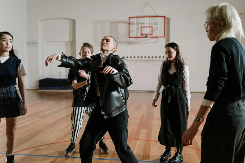 a group of people standing on top of a wooden floor, an album cover, unsplash, antipodeans, hitler playing basketball, goth people dancing, school class, thumbnail