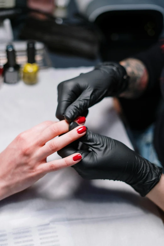 a woman getting her nails done at a salon, a tattoo, by Julia Pishtar, wearing gloves, thumbnail, synthetic, with black