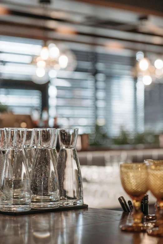 a bunch of glasses sitting on top of a counter, chefs table, indoor setting, soft natural light, rituals