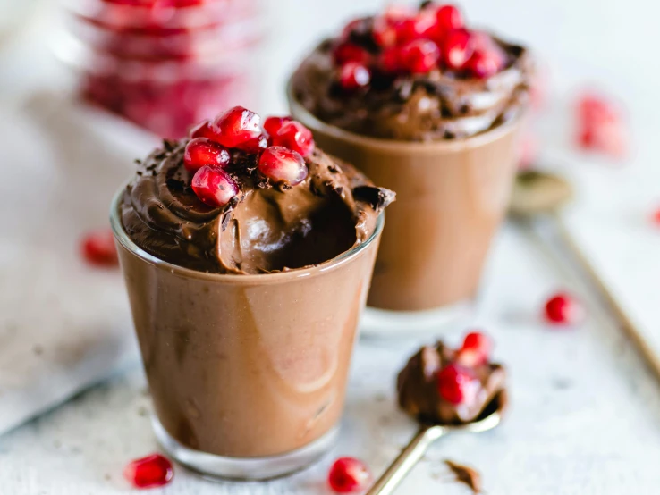 two cups of chocolate pudding topped with pomegranate, by Julia Pishtar, trending on pexels, full body close-up shot, 🎀 🧟 🍓 🧚, thumbnail, background image