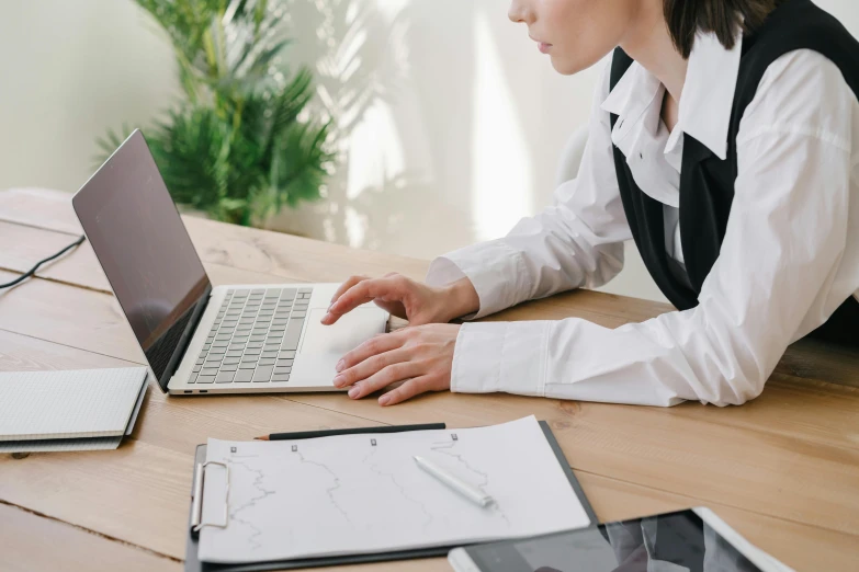 a woman sitting at a desk using a laptop computer, trending on pexels, analytical art, wearing a white blouse, avatar image, a wooden, detailed professional photo