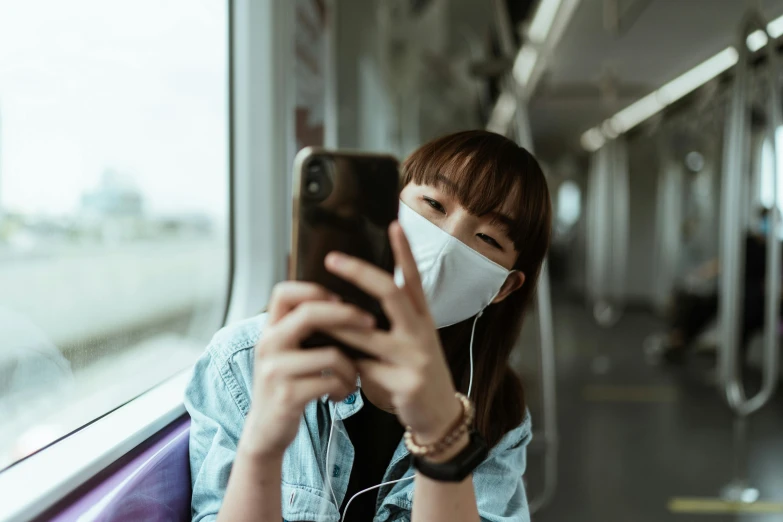 a woman wearing a face mask on a train, a picture, trending on pexels, taking a selfie, mobile game style, louise zhang, beauty is a virus