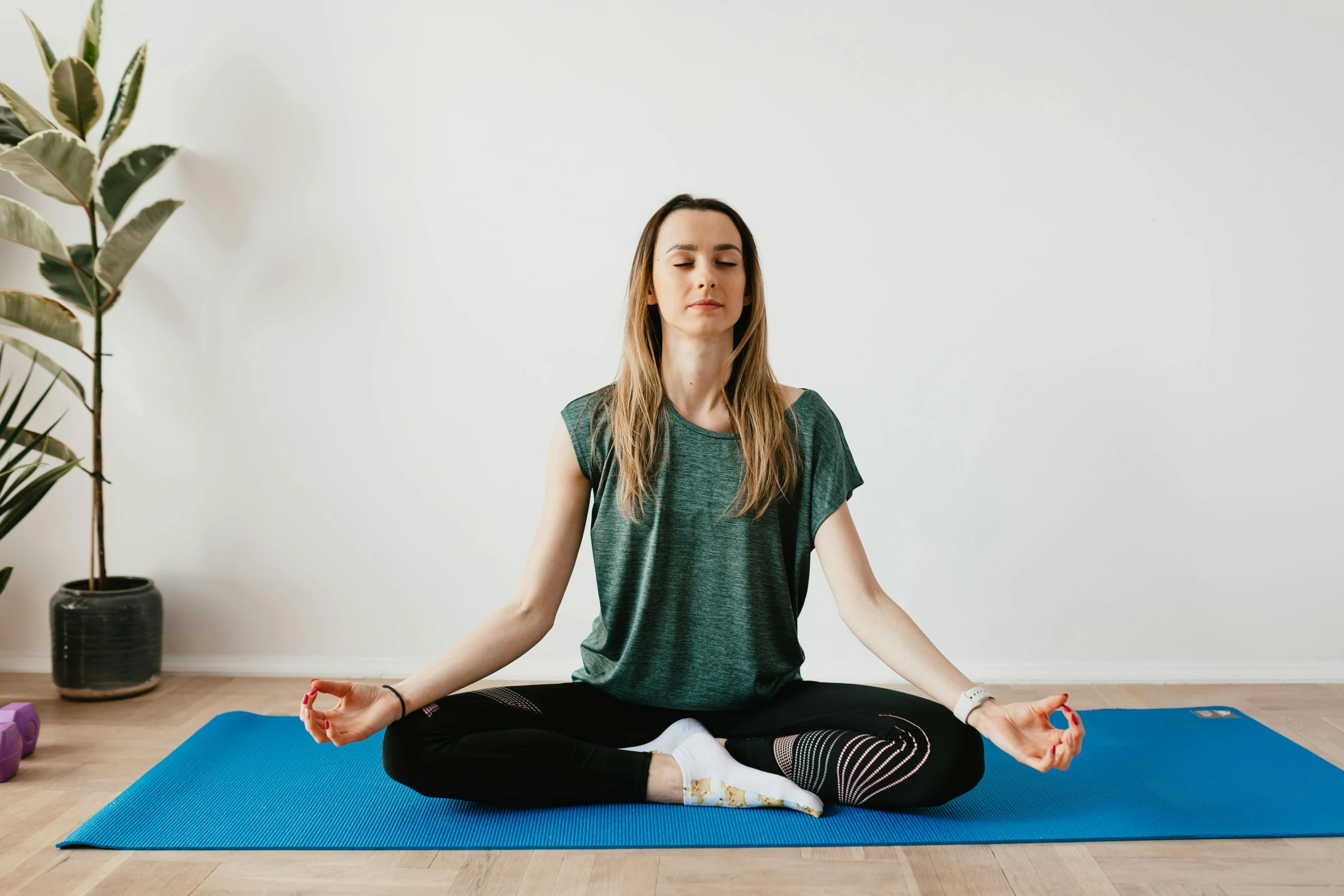 a woman sitting in a lotus position on a yoga mat, pexels contest winner, minimalism, low quality photo, background image, front facing, centred in image