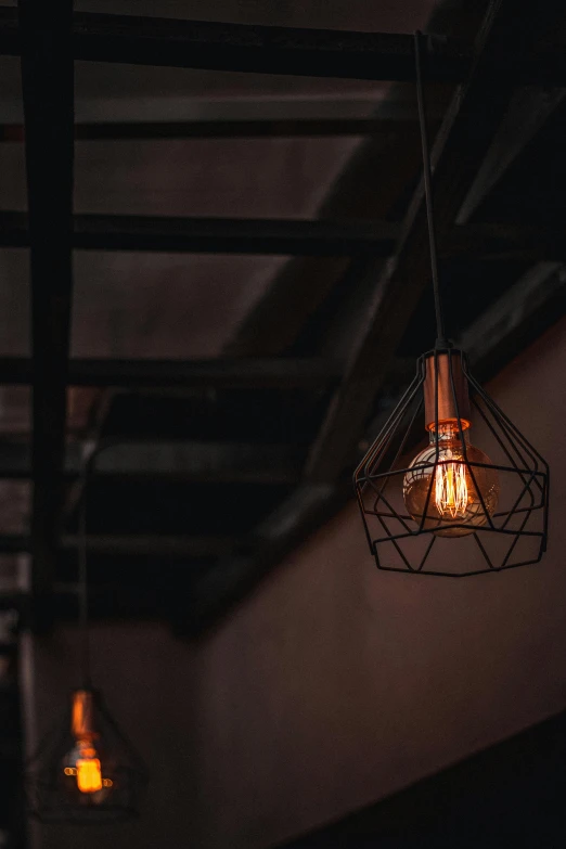 a couple of light bulbs hanging from the ceiling, by Jesper Knudsen, unsplash contest winner, gothic lighting, light inside the hut, industrial aesthetic, instagram post