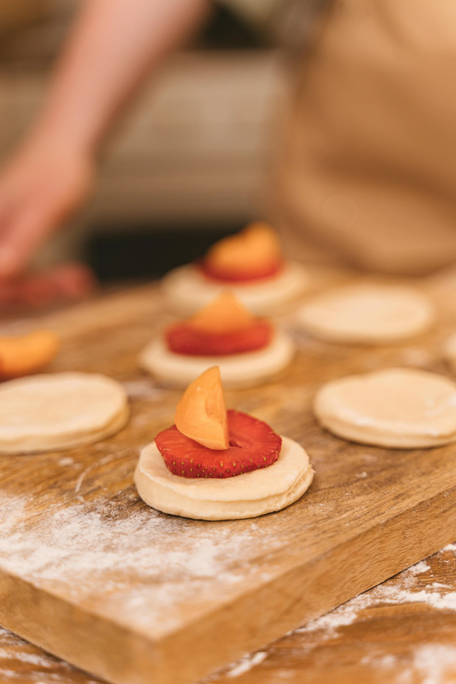 a close up of a person making food on a table, peach embellishment, crispy buns, hammershøi, cornwall