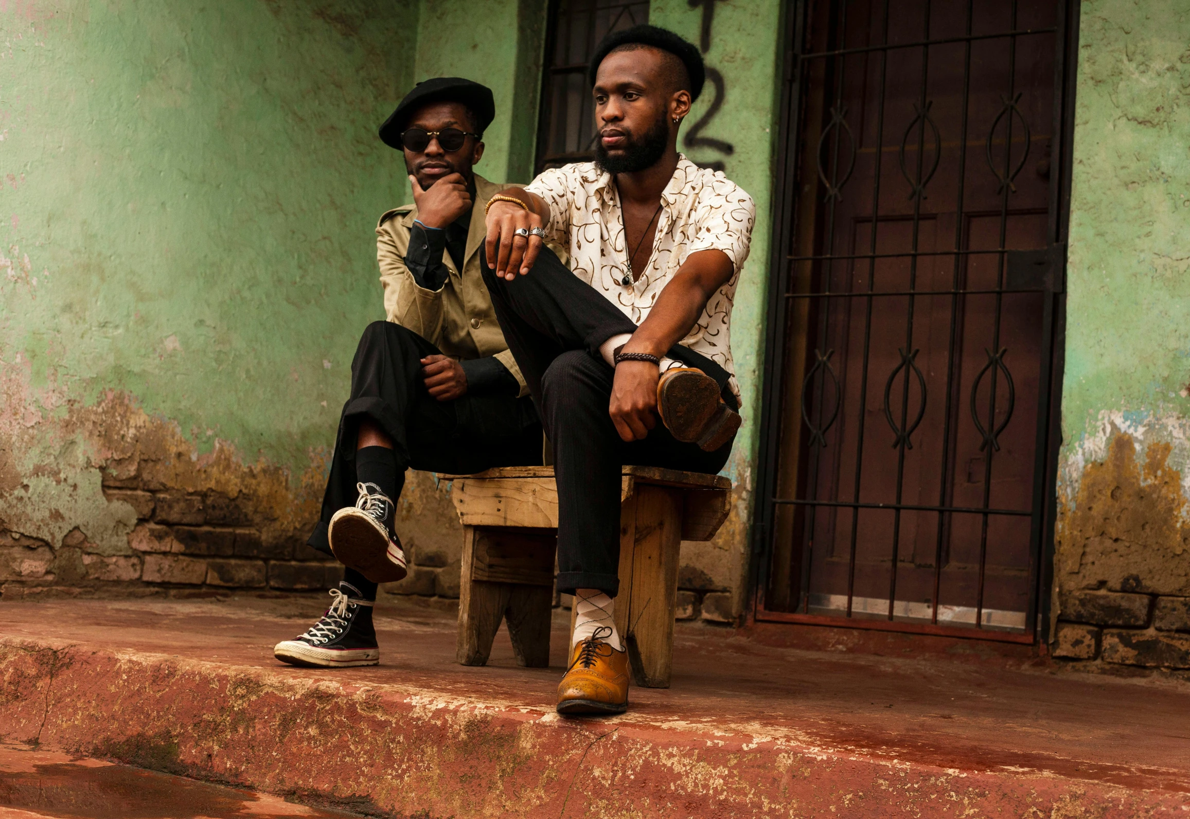 a couple of men sitting on top of a wooden bench, an album cover, by Ingrida Kadaka, pexels contest winner, afropunk, sitting on the ground, confident pose, square