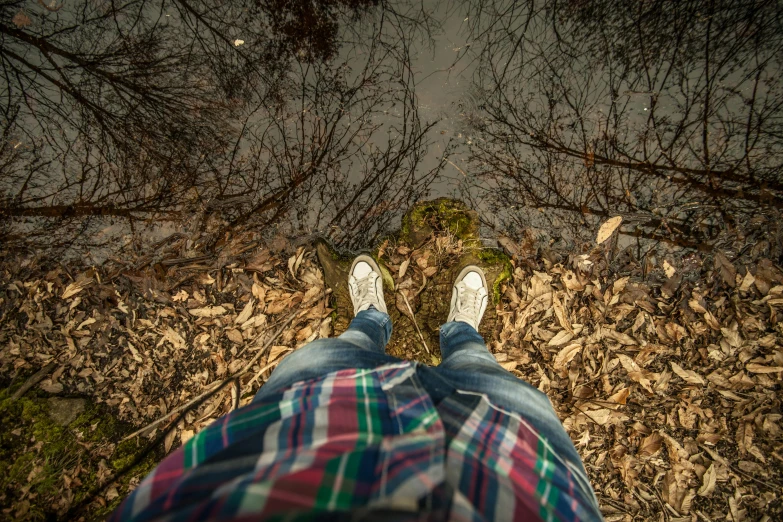 a person standing in the middle of a forest, a picture, happening, detailed shot legs-up, water reflection on the floor, top down perspecrive, autum