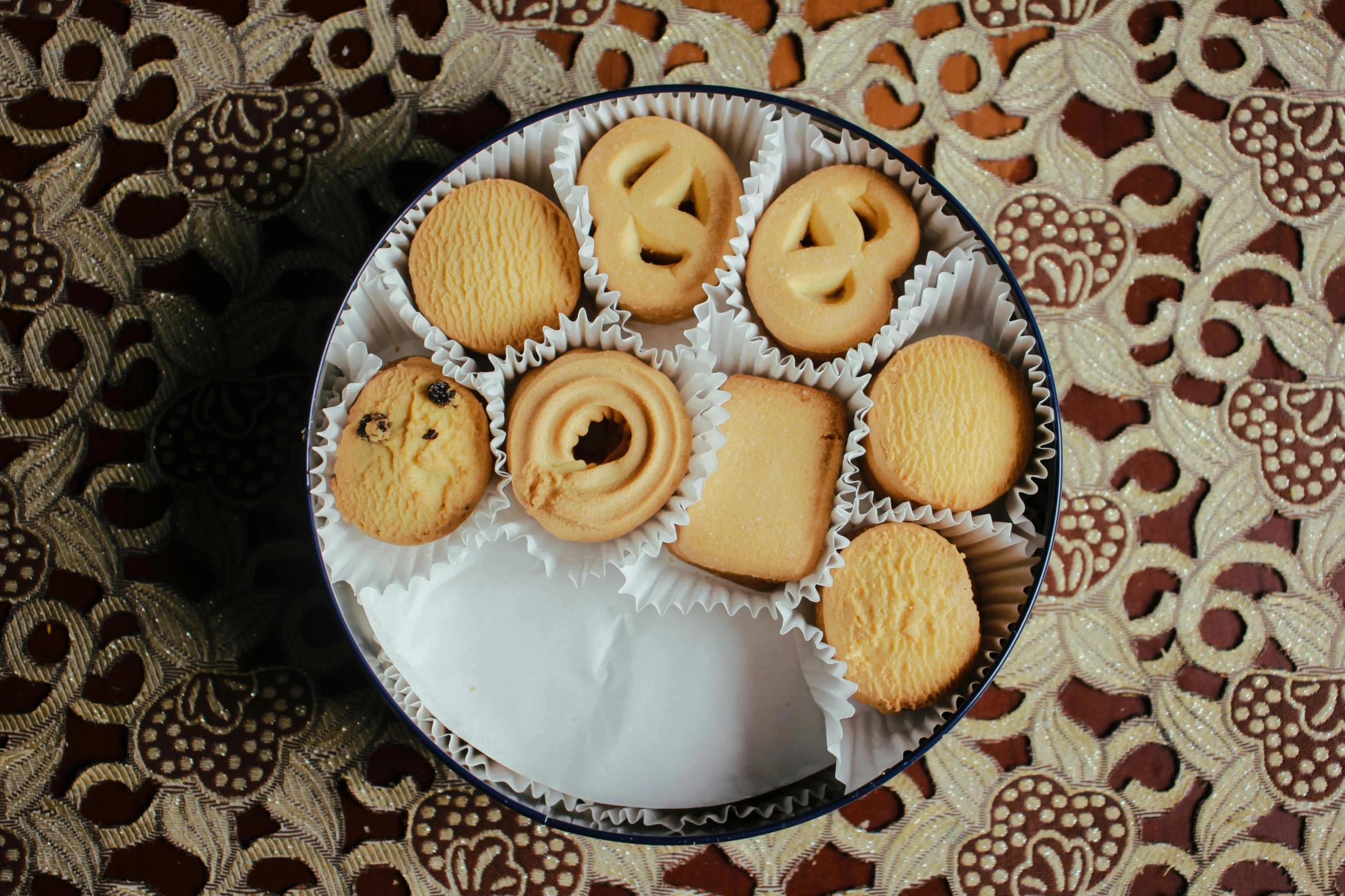 a white plate topped with cookies on top of a table, by Carey Morris, pexels contest winner, art nouveau, tins of food on the floor, diecut, middle eastern, circles