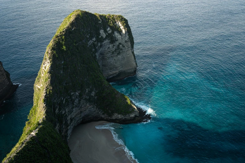 a large rock formation in the middle of a body of water, by Daniel Lieske, pexels contest winner, sumatraism, coastal cliffs, airborne view, 2 0 0 0's photo, slide show