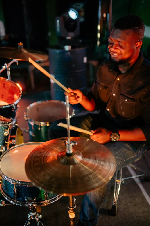 a man sitting in front of a drum set, pexels contest winner, black arts movement, emmanuel shiru, playing drums, profile image, rectangle