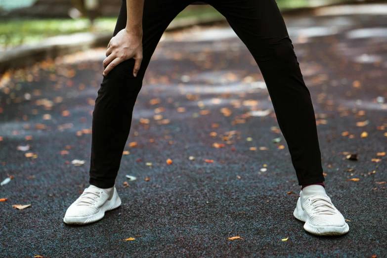 a woman holding a tennis racquet on a tennis court, by Alice Mason, pexels contest winner, leggings, at a park, his legs spread apart, standing in road