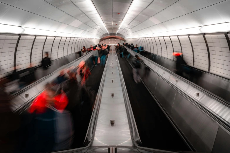 a group of people riding down an escalator, by Adam Marczyński, pexels contest winner, london underground tube station, thumbnail, monitor, ultrawide