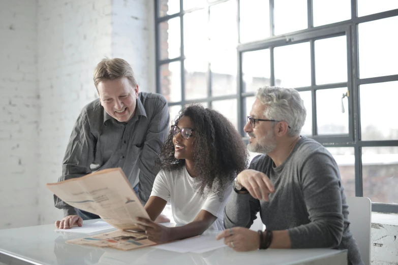 a group of people sitting around a table looking at a piece of paper, profile image, portrait image, grey, advertising photo