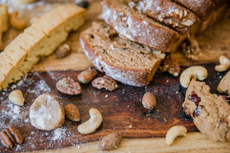 a loaf of bread sitting on top of a wooden cutting board, by Daniel Lieske, pexels, walnuts, covered in white flour, pastries, 🎀 🗡 🍓 🧚