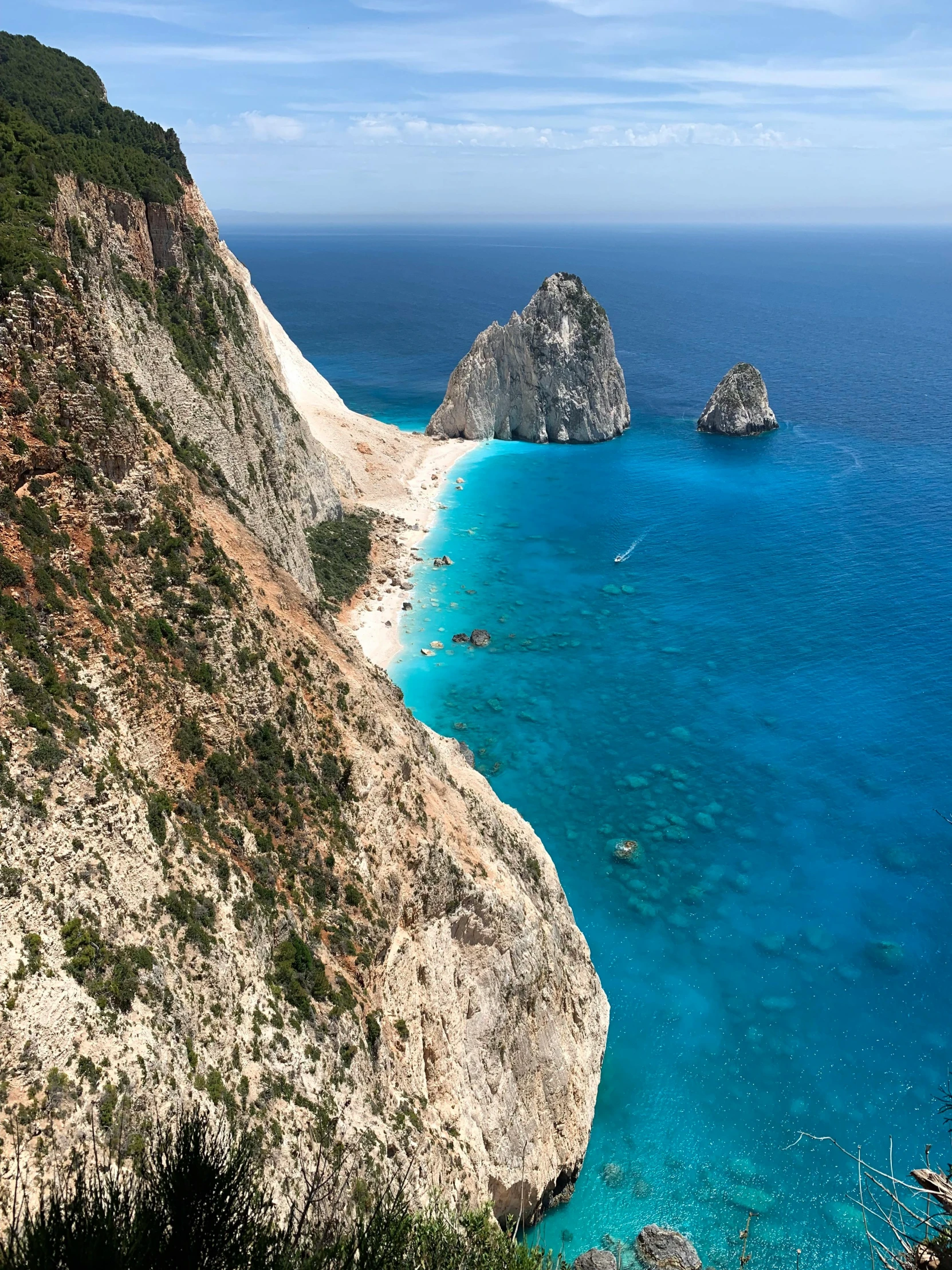 a large body of water next to a lush green hillside, pexels contest winner, greek nose, yellow and blue and cyan, coastal cliffs, square