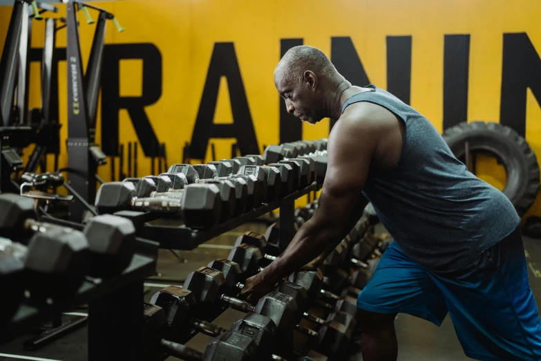 a man working out with dumbs in a gym, a portrait, by Dan Frazier, pexels contest winner, profile pic, background image, hard rain, emmanuel shiru