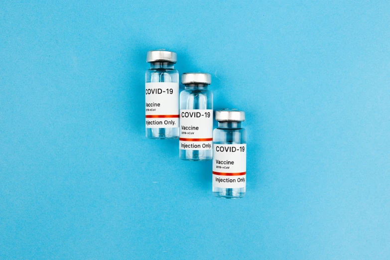 three vials sitting next to each other on a blue surface, medical labels, covid, thumbnail, thedieline