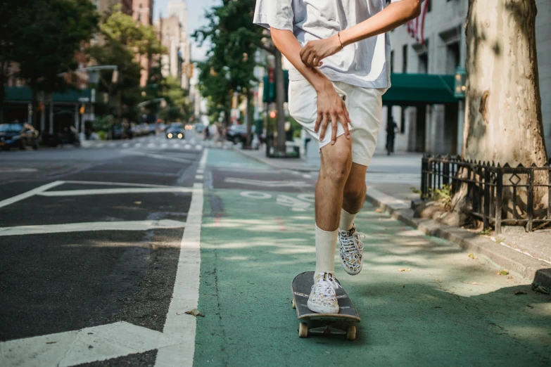 a man riding a skateboard down a street, unsplash contest winner, tan skin a tee shirt and shorts, new york streets, detailed legs towering over you, ignant