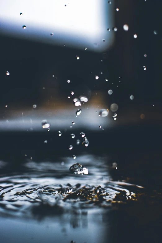 a drop of water falling into a pool of water, by Niko Henrichon, unsplash contest winner, at evening during rain, bubbly, black-water-background, partly underwater