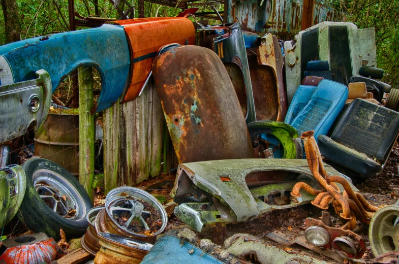 a pile of junk sitting in the middle of a forest, a still life, unsplash, assemblage, rusty vehicles, avatar image, multi - coloured, bent rusted iron