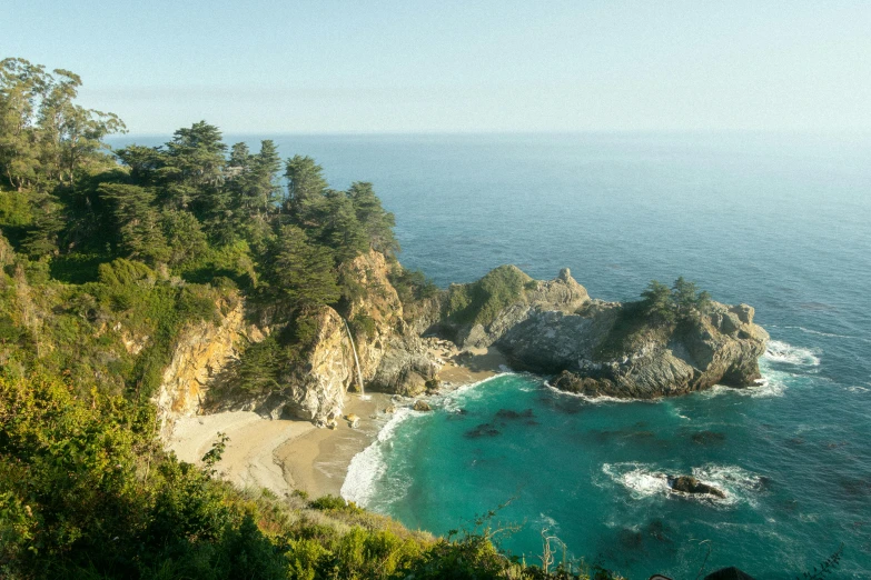 a large body of water sitting on top of a lush green hillside, by Carey Morris, pexels contest winner, beach on the outer rim, cypress trees, slim aarons, on a cliff