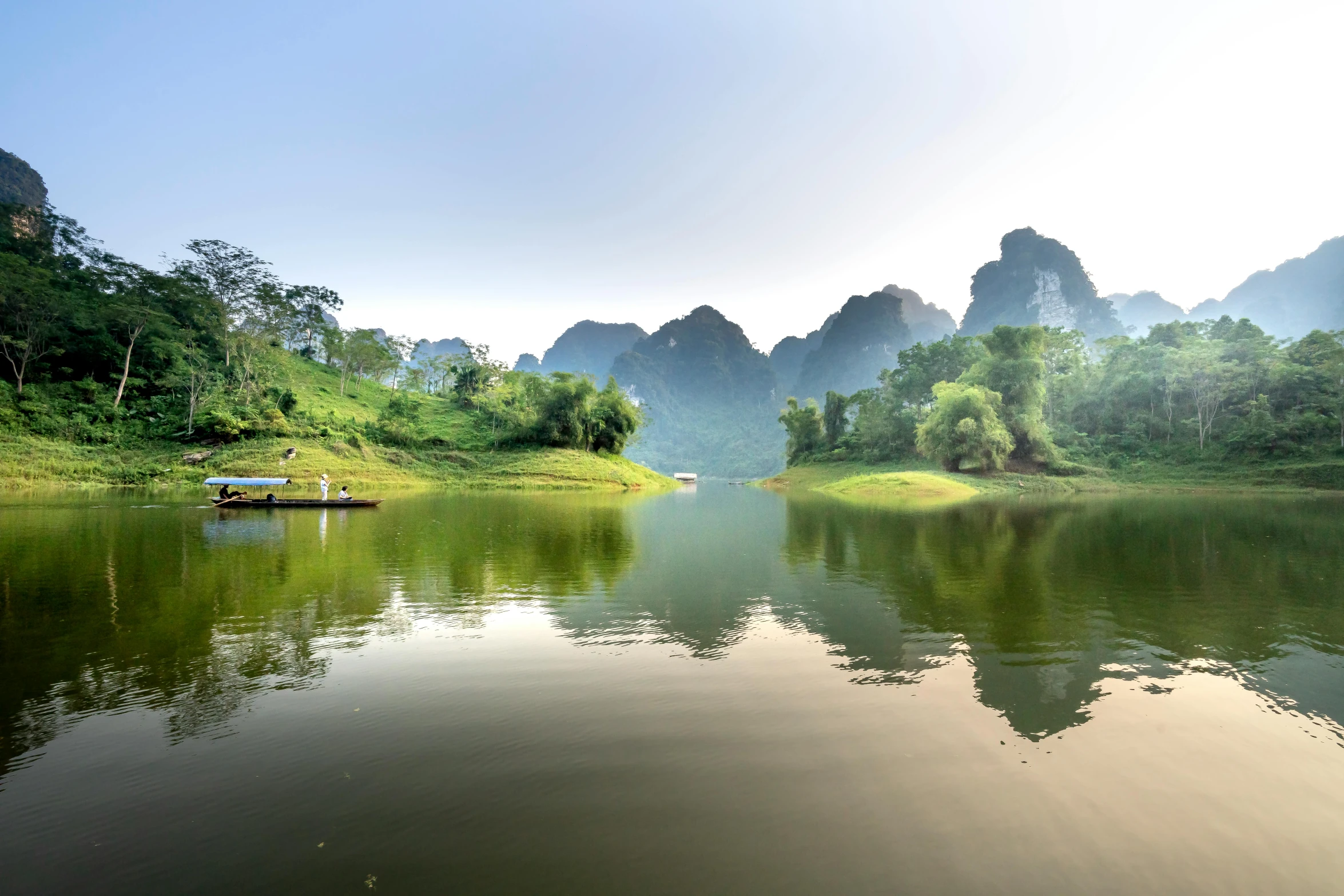 a body of water with mountains in the background, a picture, vietnam, lush valley, conde nast traveler photo, fan favorite