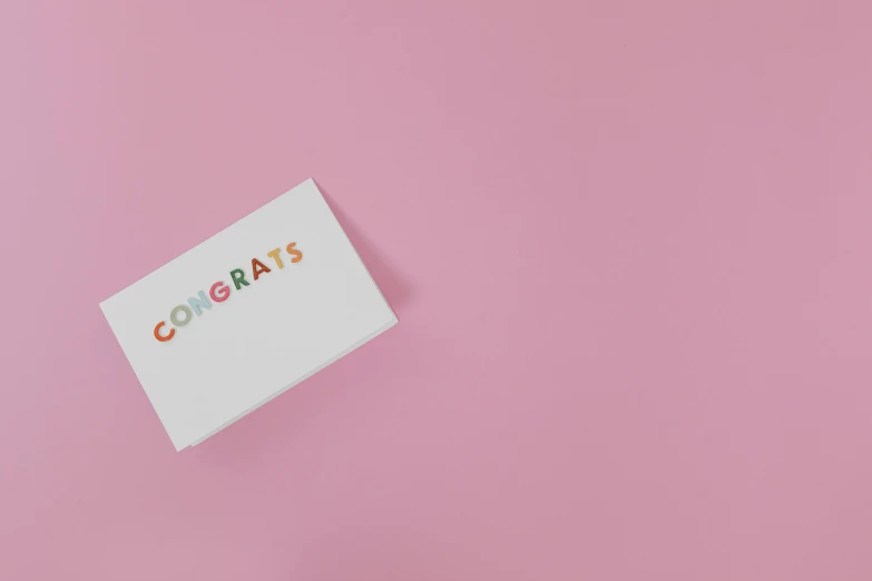 a business card sitting on top of a pink surface, by Emma Andijewska, pexels contest winner, celebrate goal, lighthearted celebration, whiteboards, pregnancy