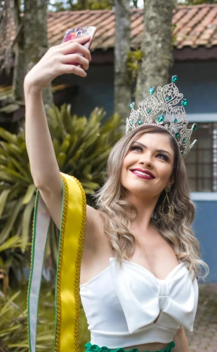 a woman wearing a crown taking a selfie, by Felipe Seade, waving and smiling, official photo, profile image, ornately dressed