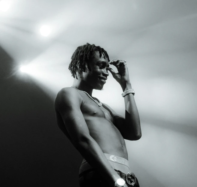 a black and white photo of a man talking on a cell phone, a black and white photo, pexels, les nabis, playboi carti, physical : tinyest midriff ever, stage photography, lights