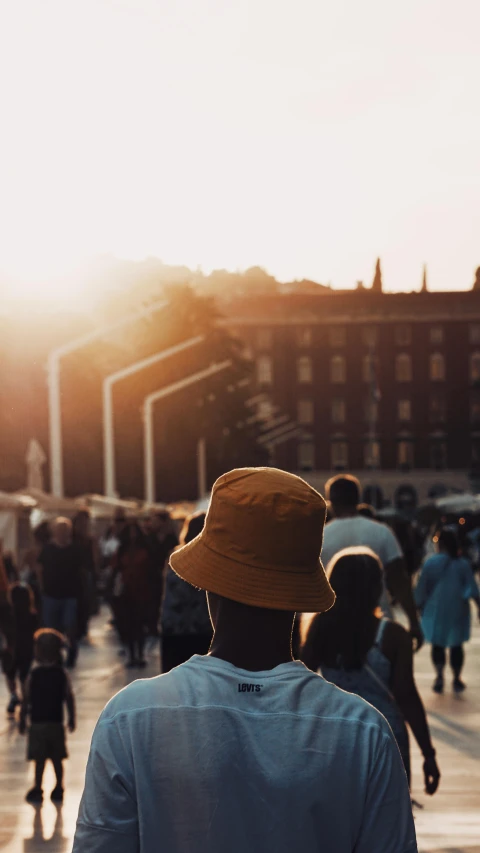 a group of people walking down a street, by Tobias Stimmer, pexels contest winner, happening, bucket hat, watching the sunset, square, museum quality photo