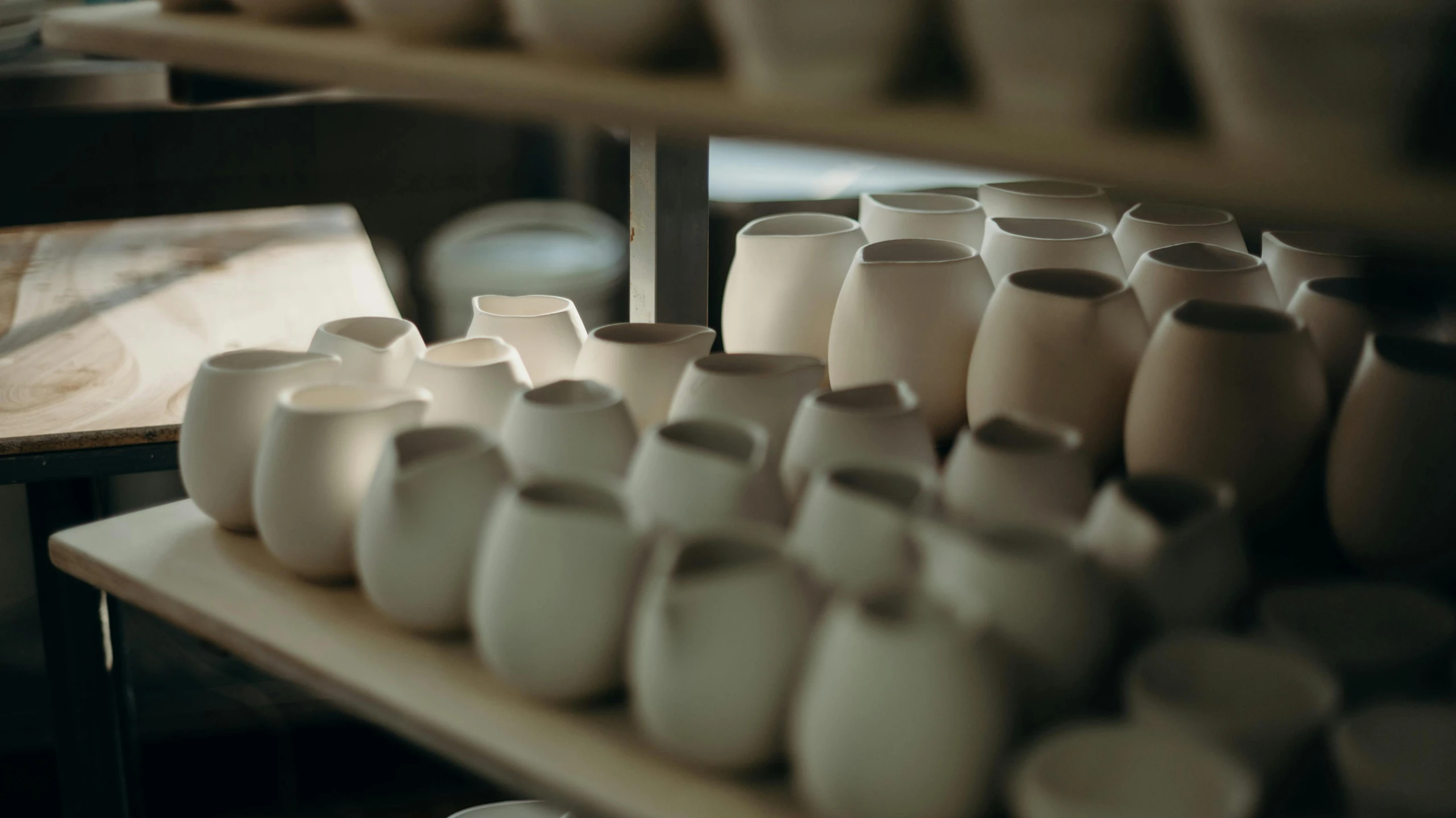 a bunch of cups that are on a shelf, a still life, by Jessie Algie, unsplash, process art, large jars on shelves, with dramatic lighting, white clay, small manufacture