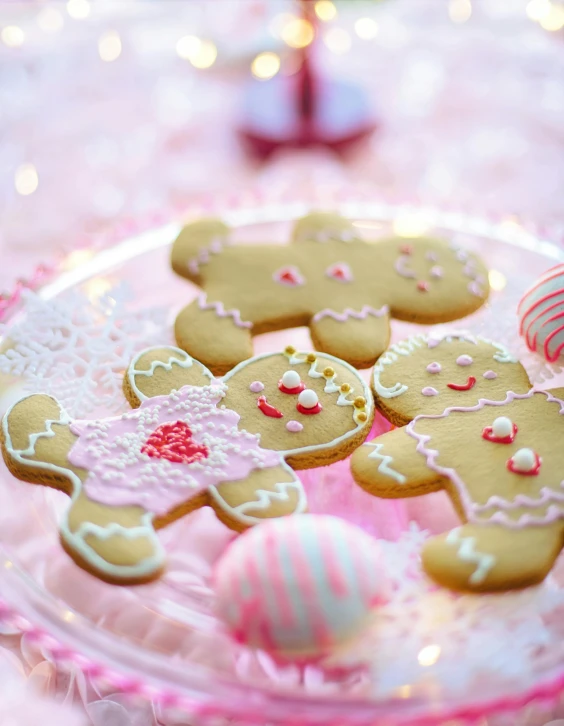 a plate that has some cookies on it, by Julia Pishtar, pexels, gingerbread people, pink pastel, 15081959 21121991 01012000 4k