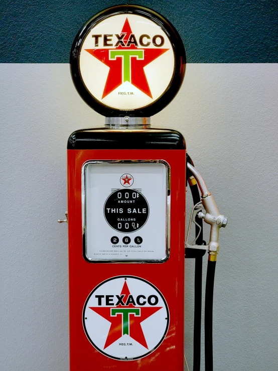 a red gas pump sitting next to a white wall, poster art, by Everett Warner, pexels contest winner, photorealism, 2 5 6 x 2 5 6 pixels, old signs, high angle close up shot, on display in a museum