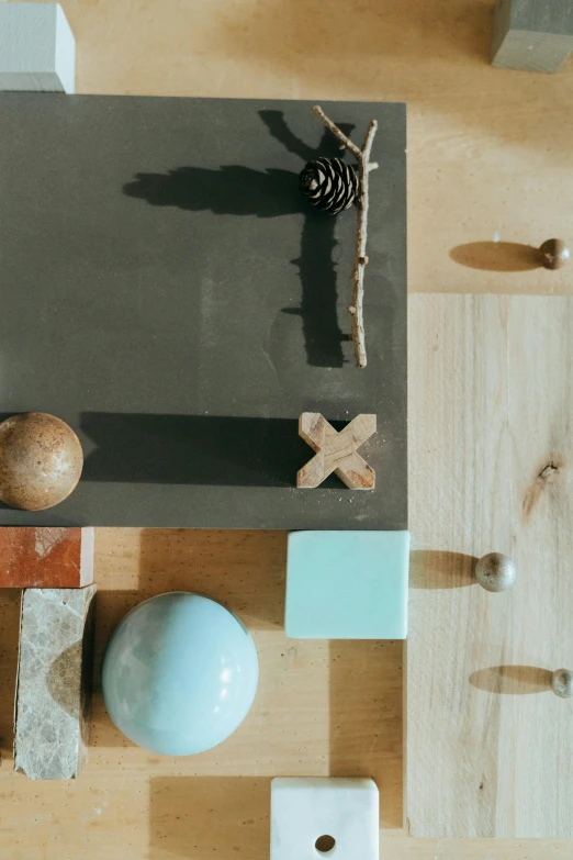 a table topped with assorted objects on top of a wooden floor, inspired by Constantin Hansen, trending on unsplash, conceptual art, brown and cyan blue color scheme, knobs, holding a wood piece, 15081959 21121991 01012000 4k