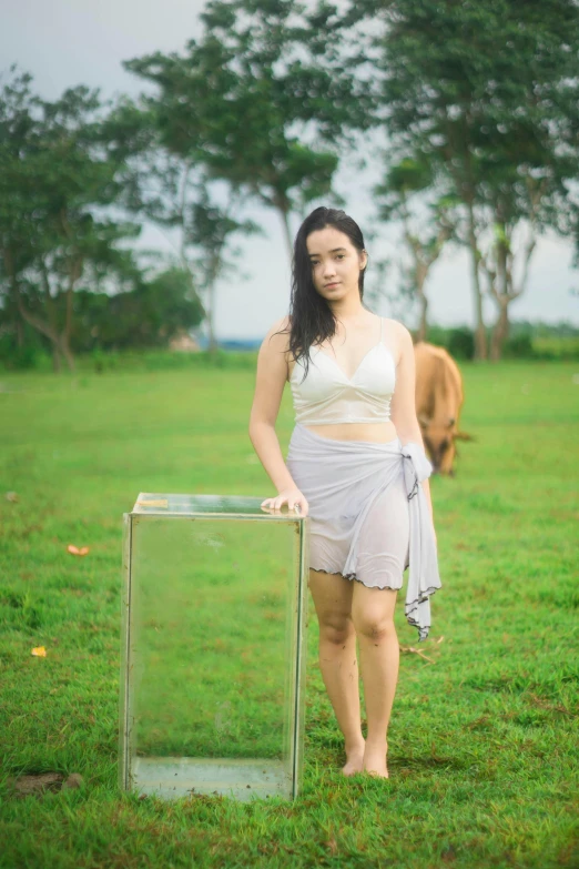 a woman standing in a field with a cow behind her, by Basuki Abdullah, unsplash, conceptual art, white skirt and barechest, with clear glass, 8k octan photo, young asian girl