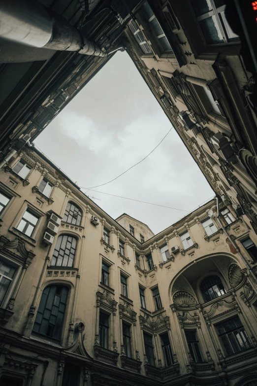 a very tall building with a skylight above it, inspired by Mihály Munkácsy, unsplash contest winner, neoclassicism, lviv, collapsed buildings, courtyard, street of moscow