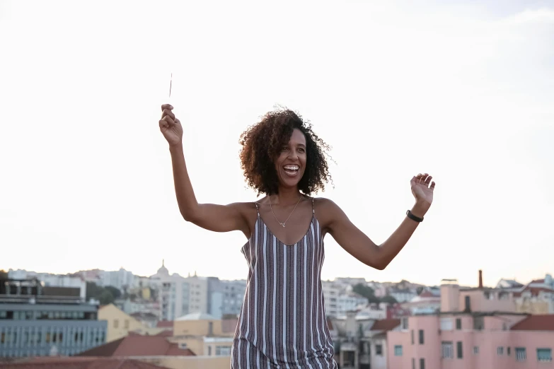 a woman standing on top of a roof holding a kite, pexels contest winner, dark short curly hair smiling, beautiful city black woman only, in a white tank top singing, lisbon
