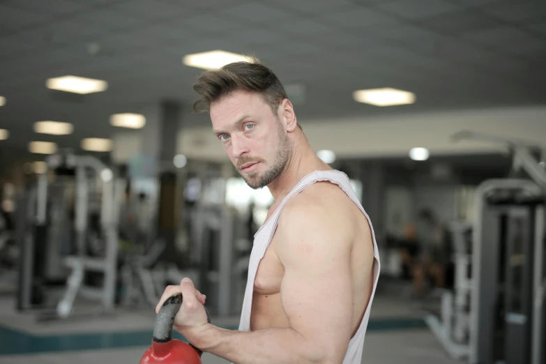 a man standing next to a machine in a gym, by Exekias, pexels contest winner, renaissance, 30 year old man :: athletic, profile image