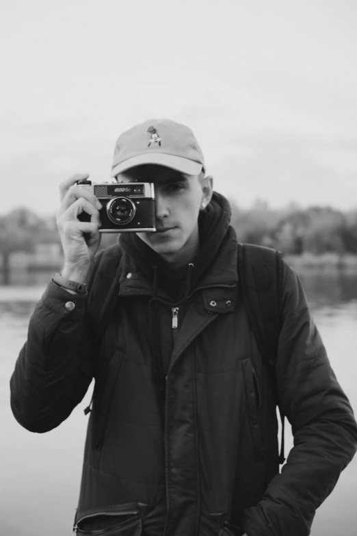 a man taking a picture with a camera, a black and white photo, inspired by Seb McKinnon, river in front of him, chillhop, professional profile picture, blank stare