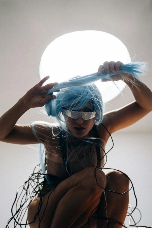 a woman with blue hair sitting on top of a bed, inspired by Shigeru Aoki, trending on pexels, conceptual art, oled visor over eyes, fiberoptic hair, sun overhead, “house music rave with dancers