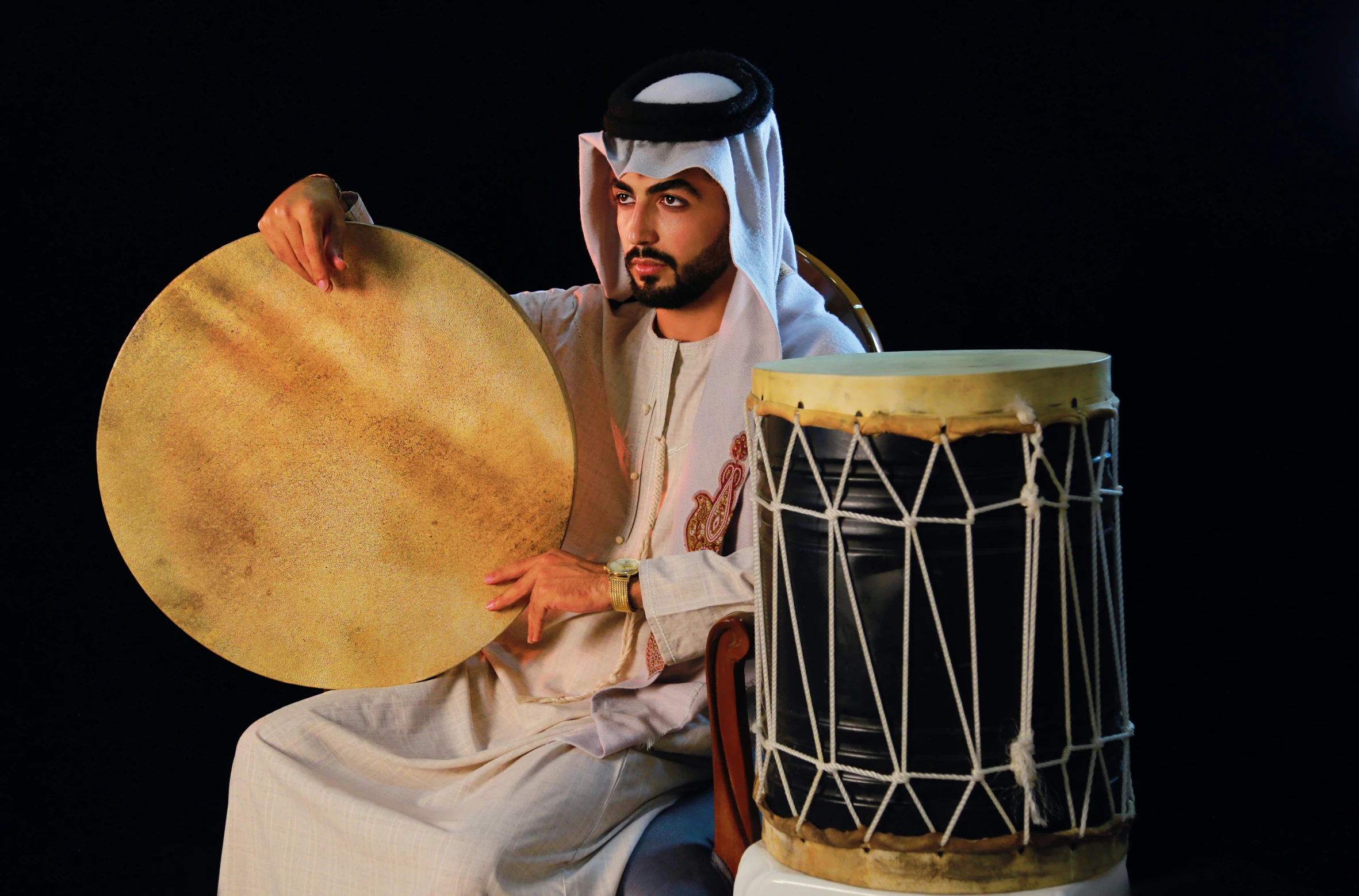 a man that is sitting down with a drum, dau-al-set, arab ameera al taweel, rhythm & hues, information, gulf