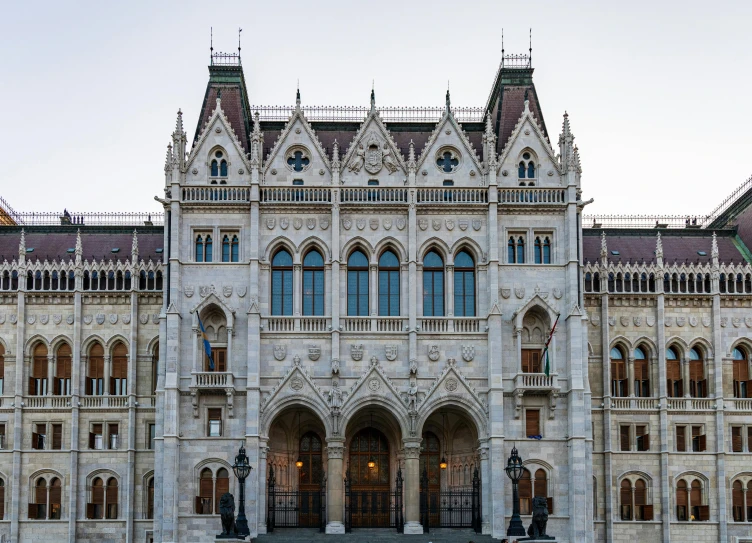 a large building with a clock on the front of it, inspired by Mihály Munkácsy, heavily gothic ornamental, politicians, grey, brown