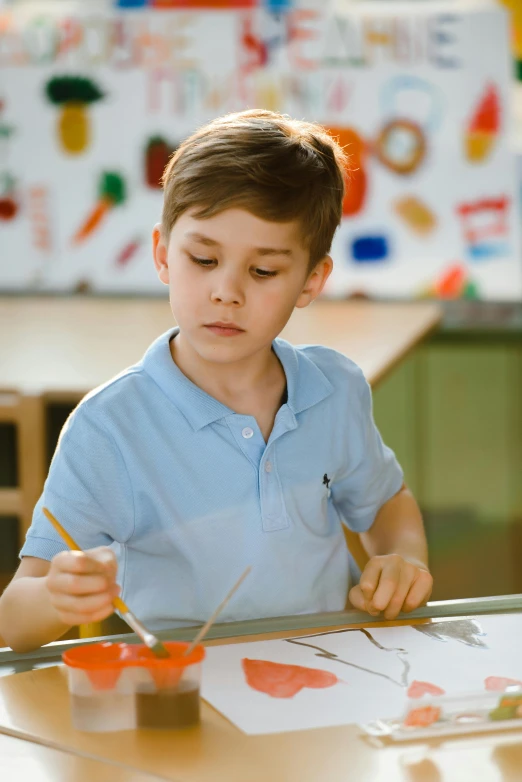 a little boy that is sitting at a table, a child's drawing, inspired by Gerard David, pexels contest winner, process art, holding a paintbrush, in a school classroom, concentrated look, slightly sunny