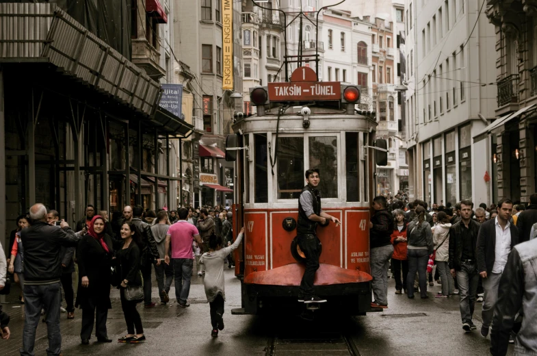 a group of people walking down a street next to a trolley, by Niyazi Selimoglu, pexels contest winner, art nouveau, square, ottoman sultan, brown, thanks