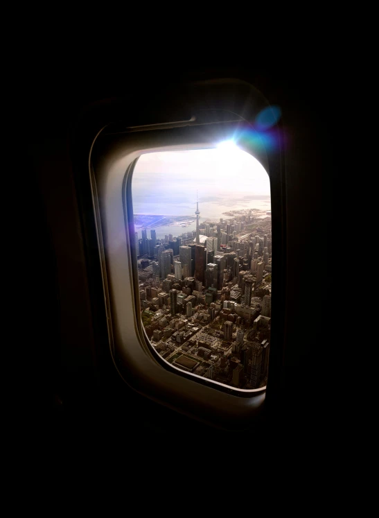 a view of a city from an airplane window, happening, with glowing windows, cn tower, open window, airing in 2 0 2 3