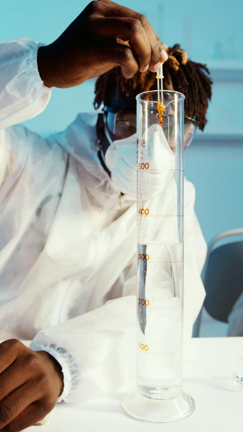 a person sitting at a table with a glass filled with liquid, pexels, process art, wearing a labcoat, student, bong, banner